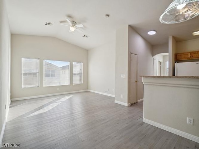 4830 Double Down Dr Unit 102, Las Vegas, NV 89122 - unfurnished living room featuring light wood-type flooring, arched walkways, a ceiling fan, baseboards, and lofted ceiling