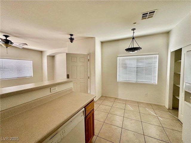 4830 Double Down Dr Unit 102, Las Vegas, NV 89122 - kitchen with decorative light fixtures, ceiling fan, light tile patterned flooring, brown cabinets, and light countertops