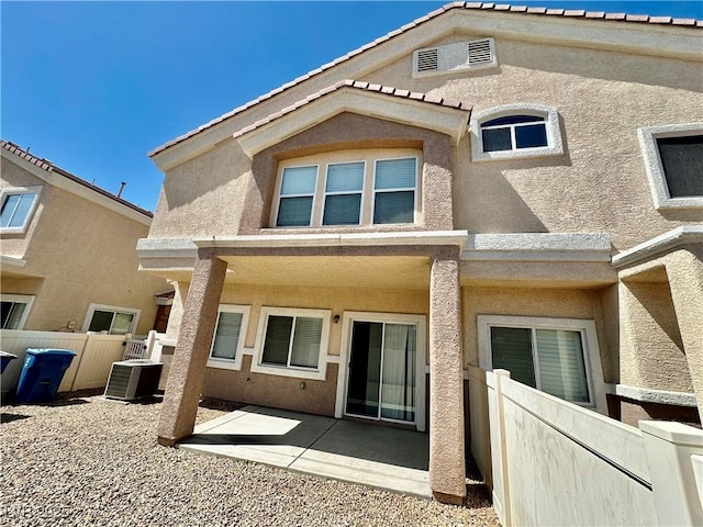 4830 Double Down Dr Unit 102, Las Vegas, NV 89122 - rear view of house featuring stucco siding, fence, central AC, and a patio area