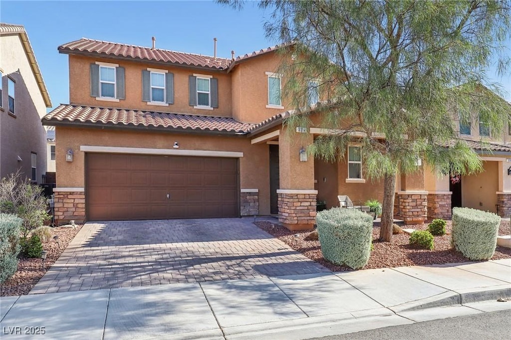 334 E Neal Ave, Las Vegas, NV 89183 - view of front of property featuring stone siding, an attached garage, stucco siding, driveway, and a tiled roof