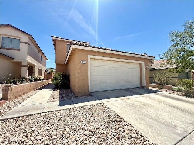view of front of house featuring stucco siding, concrete driveway, a tile roof, and an attached garage