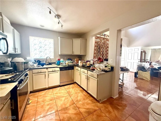 kitchen featuring stainless steel appliances, light tile patterned floors, a sink, and open floor plan