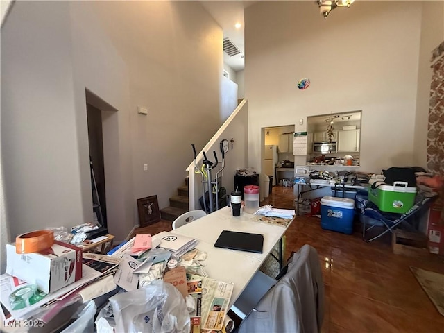 dining room with stairway and a towering ceiling