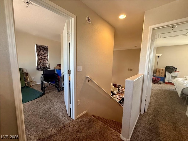 hall with an upstairs landing and carpet floors