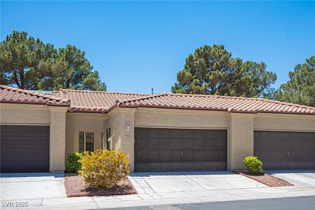 mediterranean / spanish house with a tiled roof, stucco siding, and an attached garage