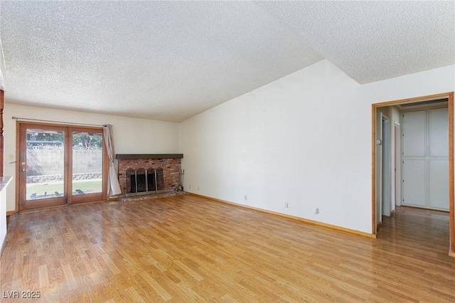 2700 Osborne Ln, Henderson, NV 89014 - unfurnished living room with a textured ceiling, light wood finished floors, a brick fireplace, and baseboards