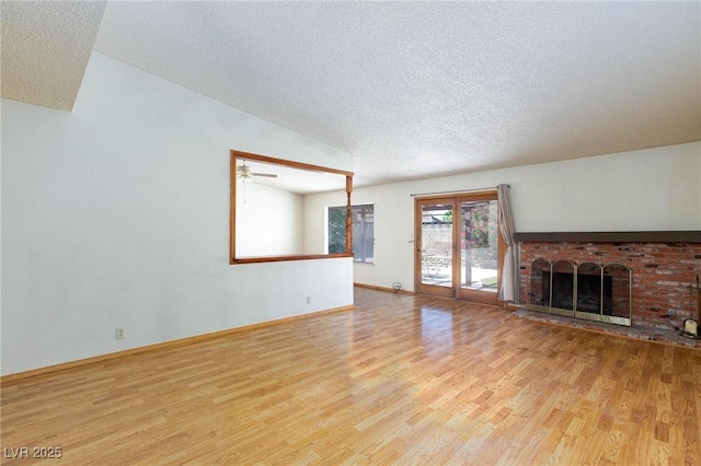2700 Osborne Ln, Henderson, NV 89014 - unfurnished living room with wood finished floors, a textured ceiling, a brick fireplace, a ceiling fan, and baseboards