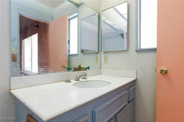 2700 Osborne Ln, Henderson, NV 89014 - bathroom with plenty of natural light, vanity, and wallpapered walls