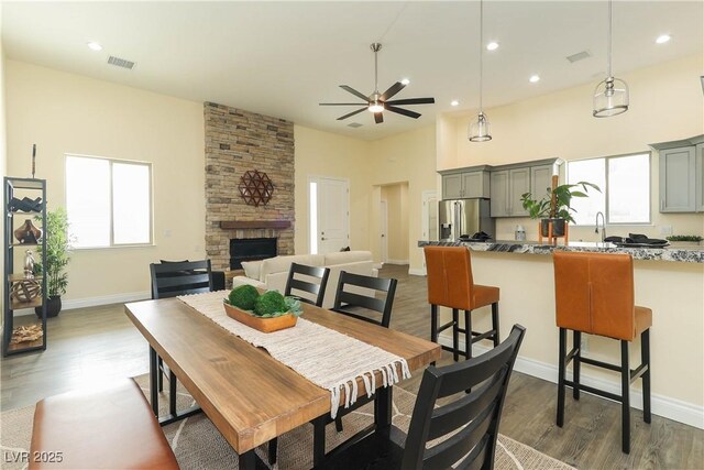 1409 Denver St, Boulder City, NV 89005 - dining space featuring healthy amount of natural light, ceiling fan, a stone fireplace, dark wood-style floors, and recessed lighting