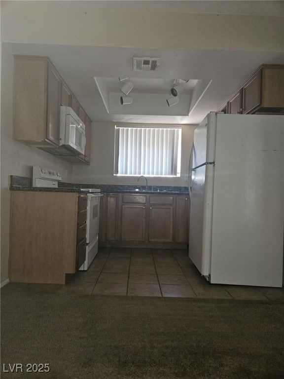 7300 Pirates Cove Rd Unit 2025, Las Vegas, NV 89145 - kitchen with white appliances, a tray ceiling, dark countertops, and light tile patterned floors