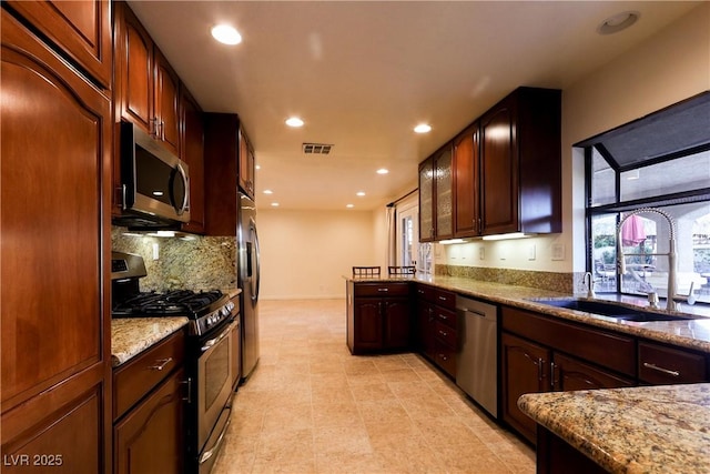 1440 Rawhide Rd, Boulder City, NV 89005 - kitchen featuring stainless steel appliances, plenty of natural light, backsplash, light stone counters, and recessed lighting