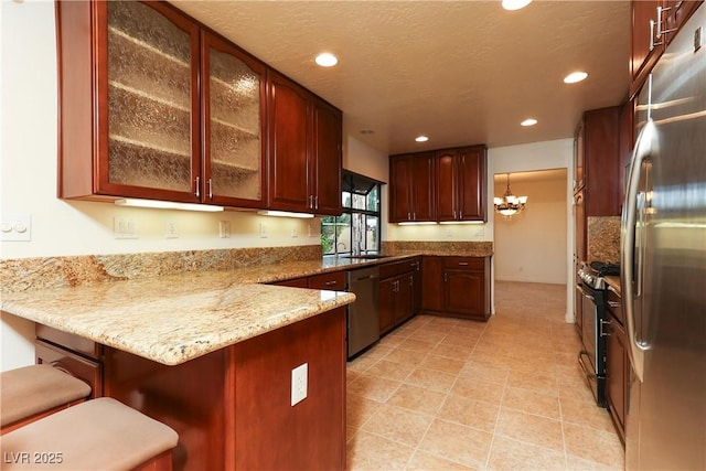 1440 Rawhide Rd, Boulder City, NV 89005 - kitchen with appliances with stainless steel finishes, a peninsula, glass insert cabinets, recessed lighting, and a kitchen breakfast bar