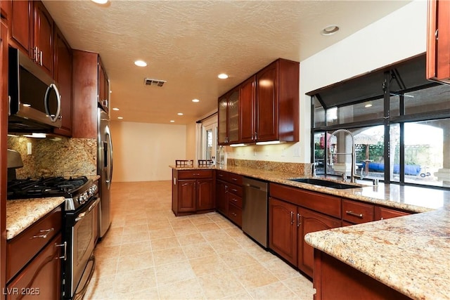 1440 Rawhide Rd, Boulder City, NV 89005 - kitchen featuring appliances with stainless steel finishes, a sink, recessed lighting, a peninsula, and light stone counters