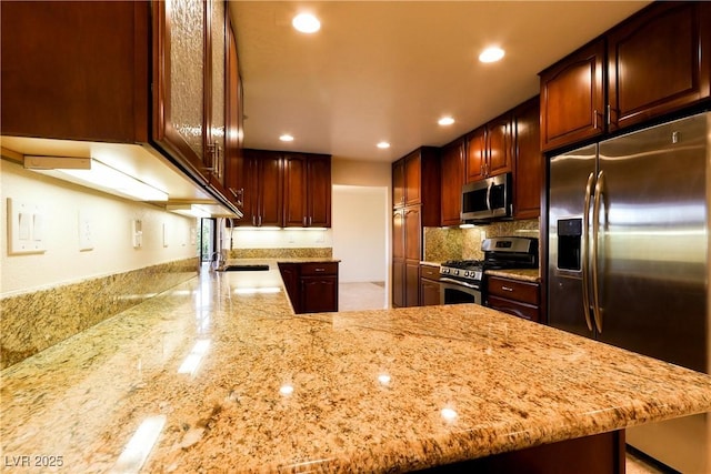 1440 Rawhide Rd, Boulder City, NV 89005 - kitchen with stainless steel appliances, light stone counters, backsplash, recessed lighting, and a peninsula