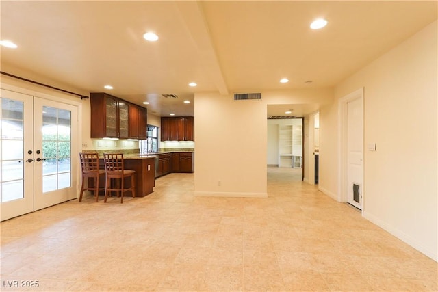 1440 Rawhide Rd, Boulder City, NV 89005 - kitchen with french doors, recessed lighting, glass insert cabinets, a breakfast bar, and baseboards