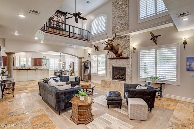 1182 Thomas Bay Cir, Logandale, NV 89021 - living area featuring arched walkways, a ceiling fan, a high ceiling, stone tile floors, and baseboards