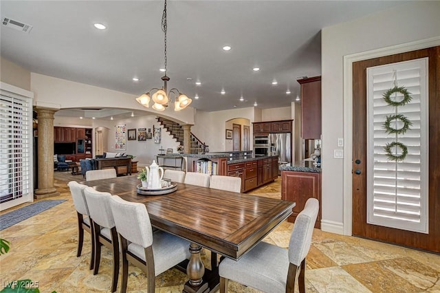 1182 Thomas Bay Cir, Logandale, NV 89021 - dining space with arched walkways, recessed lighting, decorative columns, a chandelier, and light stone finish floors