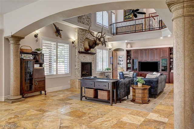 1182 Thomas Bay Cir, Logandale, NV 89021 - living room with ornate columns, arched walkways, ceiling fan, baseboards, and a towering ceiling