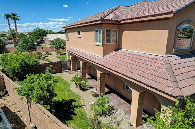 1182 Thomas Bay Cir, Logandale, NV 89021 - view of side of property with stucco siding, a tile roof, a gate, and fence