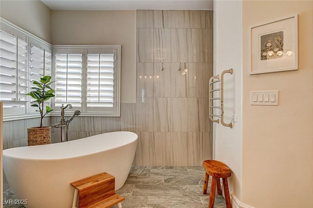 1182 Thomas Bay Cir, Logandale, NV 89021 - full bathroom with healthy amount of natural light, a freestanding tub, and tile walls