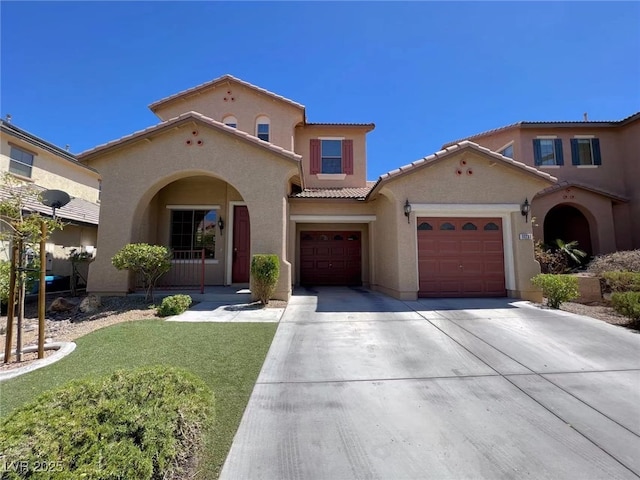 mediterranean / spanish-style home featuring stucco siding, driveway, a tile roof, a garage, and a front yard