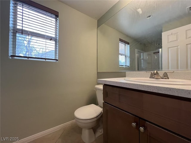 bathroom featuring a stall shower, tile patterned flooring, toilet, baseboards, and vanity