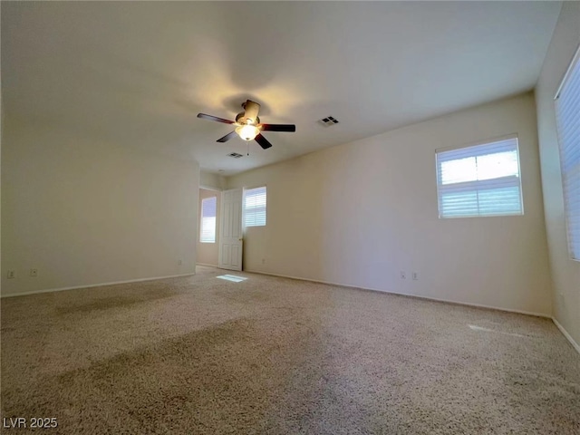 unfurnished room with carpet flooring, a ceiling fan, and baseboards