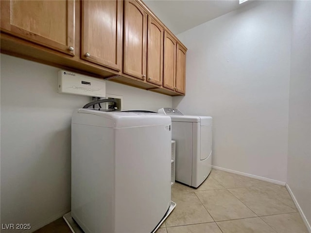laundry room with cabinet space, washer and clothes dryer, baseboards, and light tile patterned floors