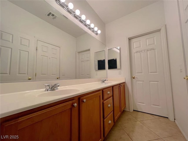 bathroom with tile patterned flooring, double vanity, and baseboards