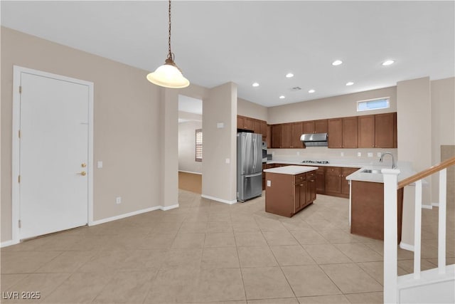 11237 Newbury Hills Ave, Las Vegas, NV 89138 - kitchen with freestanding refrigerator, under cabinet range hood, light countertops, a center island, and hanging light fixtures