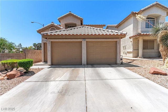 7553 Durham Hall Ave Unit 201, Las Vegas, NV 89130 - mediterranean / spanish house featuring a garage, concrete driveway, a tiled roof, and stucco siding