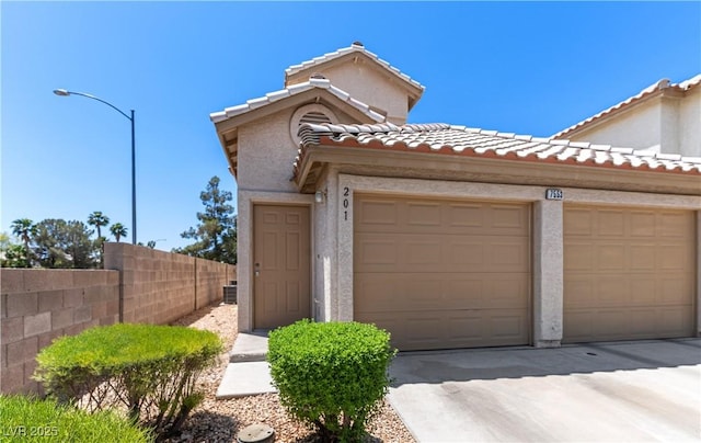 7553 Durham Hall Ave Unit 201, Las Vegas, NV 89130 - view of front facade featuring a tiled roof, stucco siding, and concrete driveway