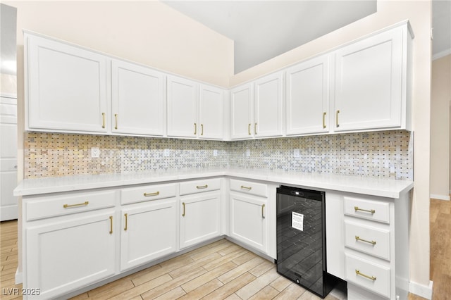 5009 Elm Grove Dr, Las Vegas, NV 89130 - kitchen with beverage cooler, light wood-style floors, light countertops, tasteful backsplash, and white cabinets