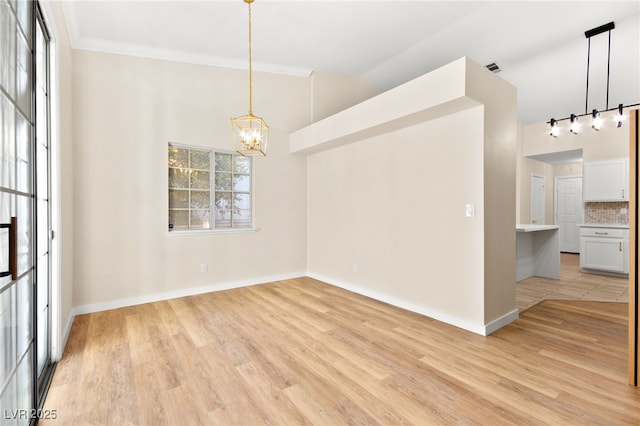 5009 Elm Grove Dr, Las Vegas, NV 89130 - spare room with a chandelier, light wood-style flooring, rail lighting, baseboards, and crown molding