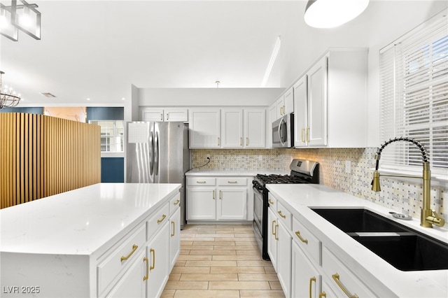5009 Elm Grove Dr, Las Vegas, NV 89130 - kitchen featuring stainless steel appliances, a sink, tasteful backsplash, white cabinets, and a center island