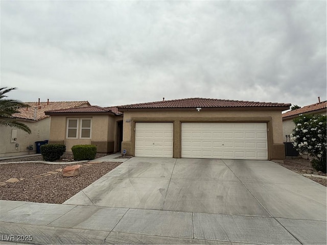 5318 Rio Eldorado Ct, North Las Vegas, NV 89031 - view of front of house featuring driveway, an attached garage, stucco siding, and a tiled roof