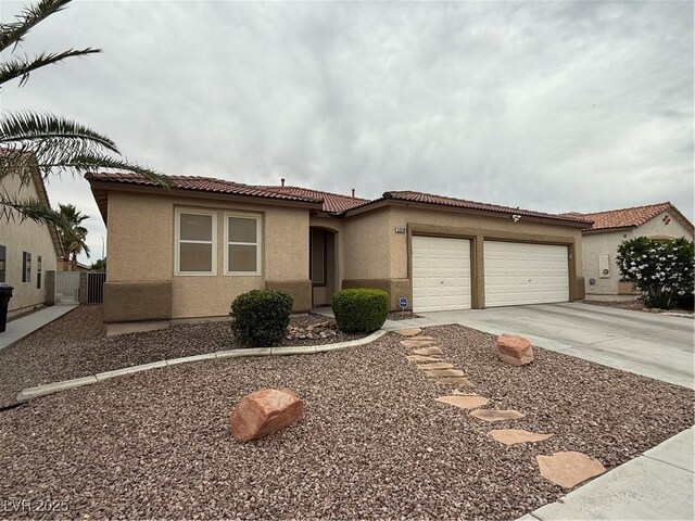 5318 Rio Eldorado Ct, North Las Vegas, NV 89031 - mediterranean / spanish-style home featuring a tile roof, stucco siding, an attached garage, and concrete driveway