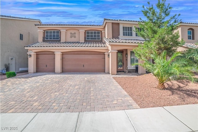 6453 Mount Eden Ave, Las Vegas, NV 89139 - mediterranean / spanish home with decorative driveway, stucco siding, a tile roof, and a garage
