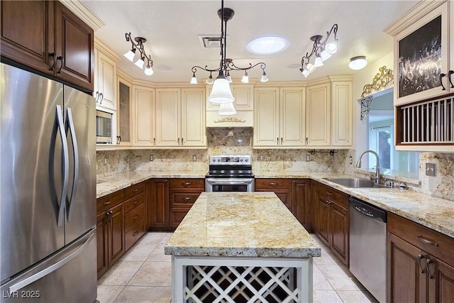 5159 N Monte Cristo Way, Las Vegas, NV 89149 - kitchen featuring stainless steel appliances, a sink, light tile patterned flooring, cream cabinetry, and tasteful backsplash