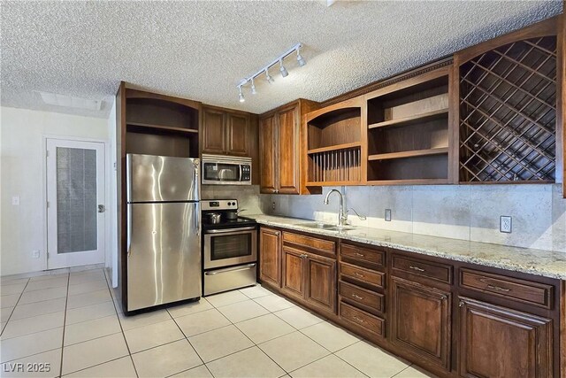 5159 N Monte Cristo Way, Las Vegas, NV 89149 - kitchen with stainless steel appliances, open shelves, a sink, track lighting, and a textured ceiling
