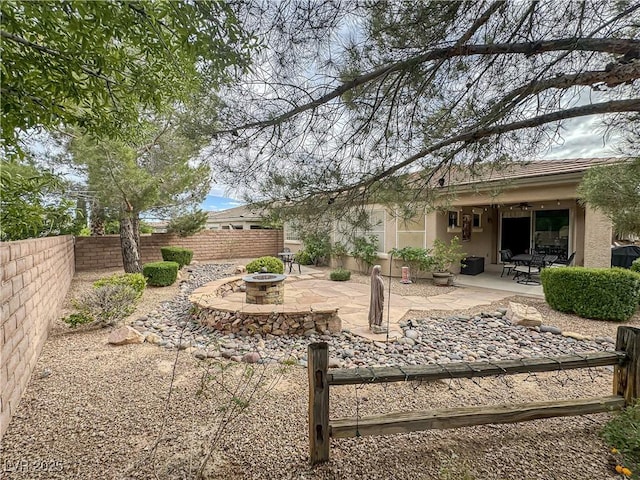fenced backyard featuring an outdoor fire pit and a patio area