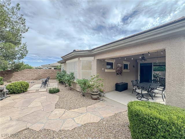 view of patio with ceiling fan, fence, and outdoor dining space