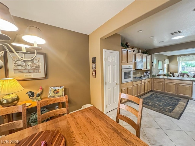 kitchen with white oven, light tile patterned floors, gas cooktop, a sink, and dishwasher