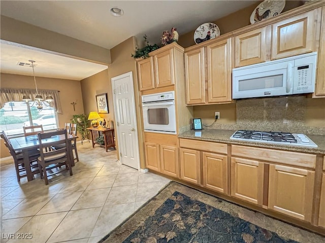kitchen with white appliances, a chandelier, light brown cabinetry, decorative backsplash, and light tile patterned flooring