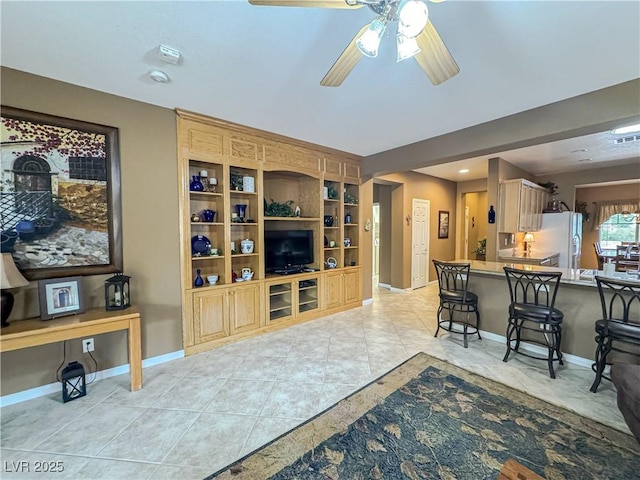 living room featuring ceiling fan, baseboards, and light tile patterned flooring