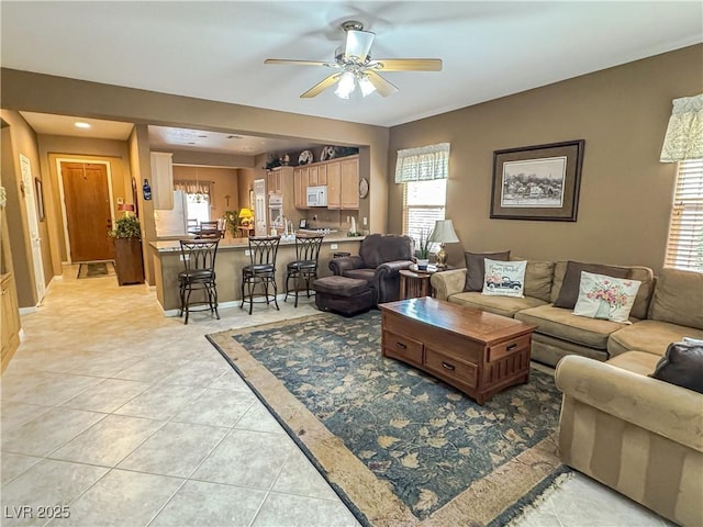 living room featuring ceiling fan and light tile patterned floors