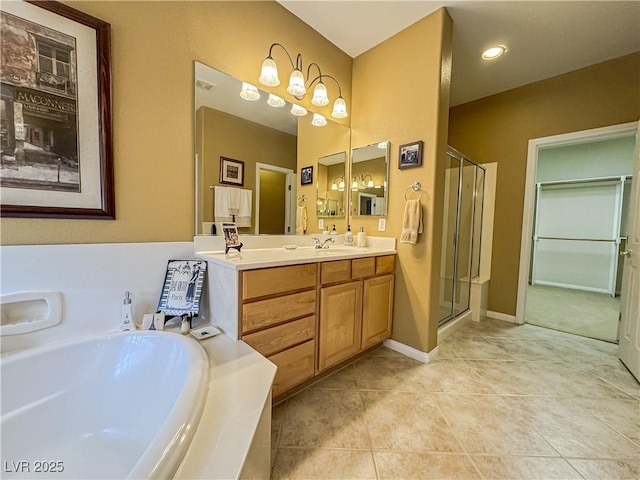 bathroom with a stall shower, vanity, a bath, and tile patterned flooring