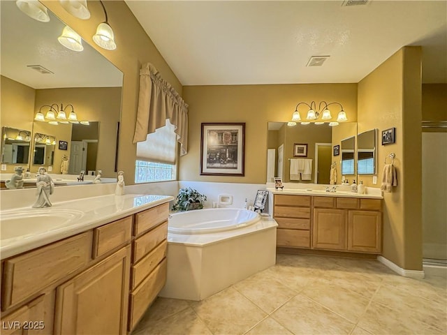 bathroom featuring tile patterned floors, a stall shower, two vanities, and a bath