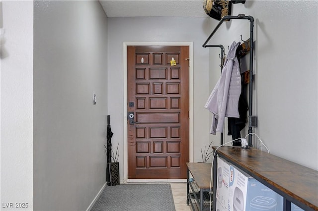 doorway to outside featuring baseboards