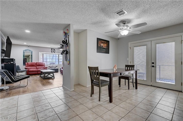 dining room with french doors, a textured ceiling, light tile patterned flooring, ceiling fan, and baseboards